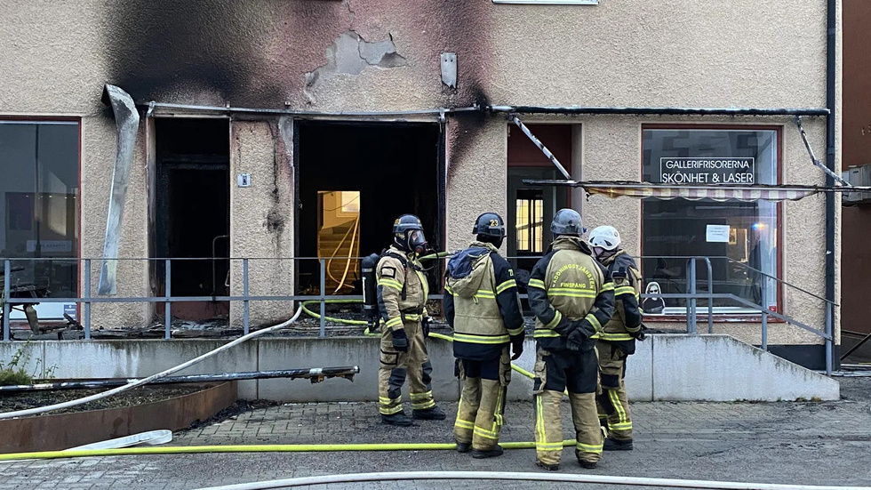 Räddningspersonal vid den förstörda lokalen efter nattens kraftiga brand.