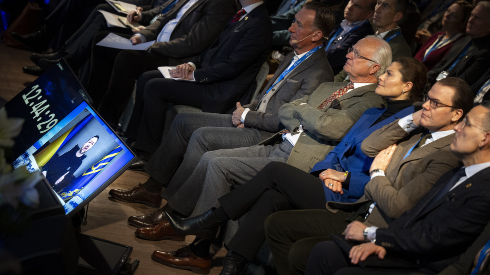 Nära kriget. Kung Carl Gustaf, kronprinsessan Victoria och prins Daniel lyssnar på Ukrainas president Volodymyr Zelenskyj som invigningstalade via länk vid Folk och Försvars rikskonferens.