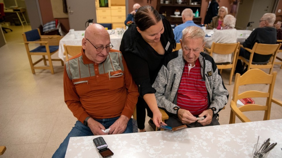 Sören Andersson och Ulf Boman får hjälp med sina mobiltelefoner av Hanna Hedlund, kommunens första digitala lots.