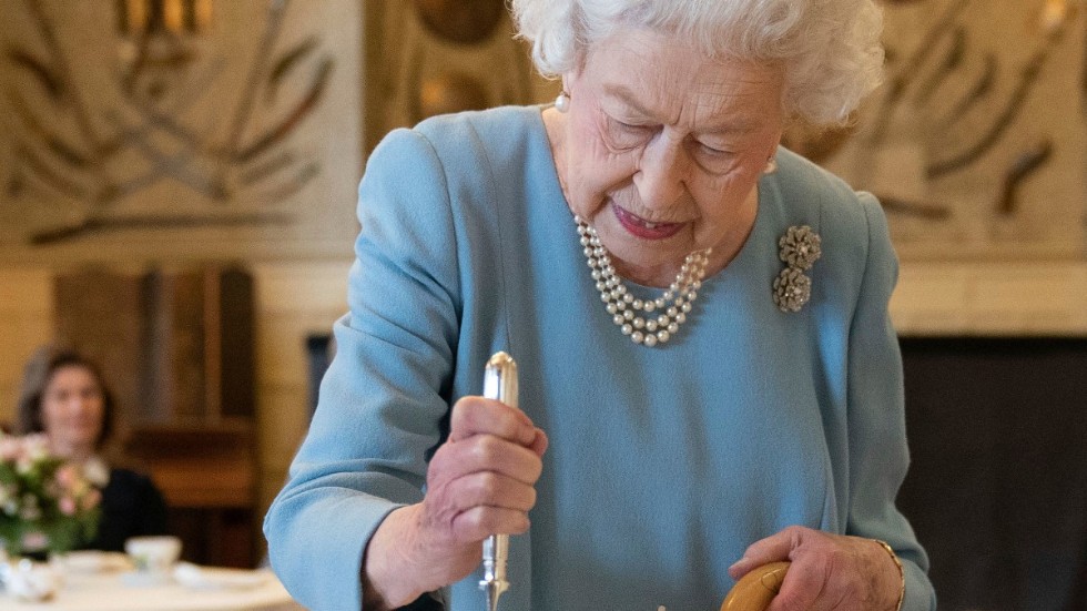 Drottning Elizabeth|II skär upp tårta till inbjudna invånare i Sandringham i England.