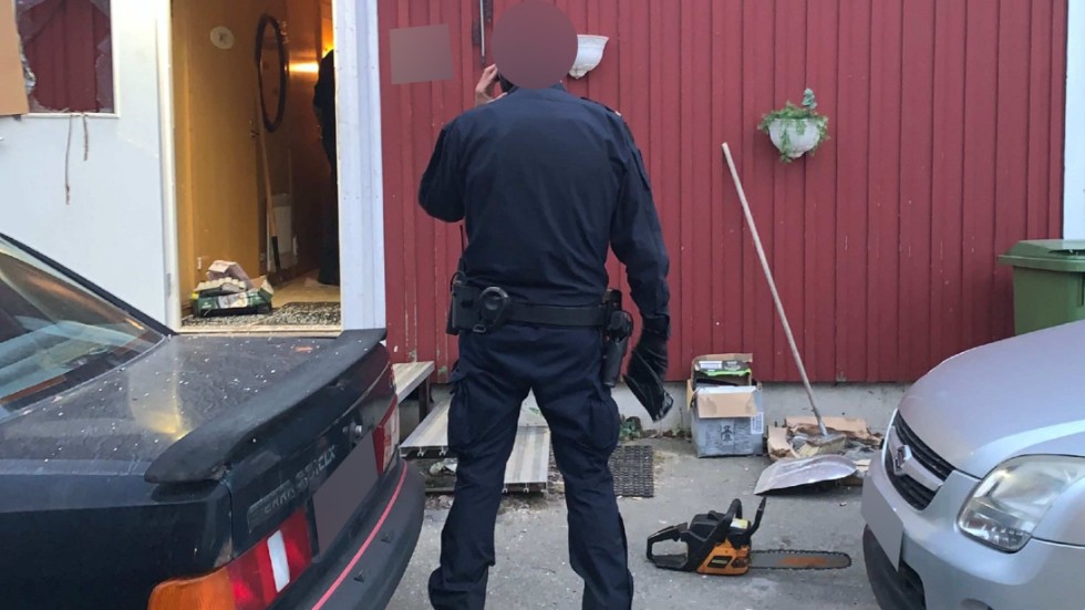 Motorsågen som ligger på asfalten kastades mot polismannen som står i bild. Den snurrande kedjan var ett par decimeter från att träffa honom. (Arkivbild)