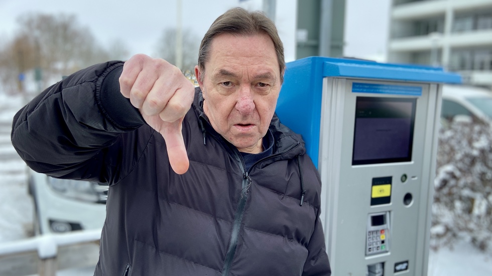 Roger Lönn ger tummen ner åt den nya parkeringsautomaten.