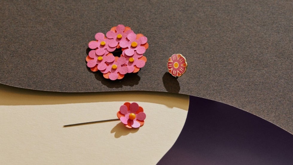 Årets majblomma går i röd-orange och rosa men kommer inte att säljas förrän i september på grund av corona-situationen.