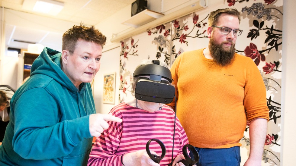 Eva Ribacke Björk testar VR för första gången. Bredvid sig har hon arbetsledarna och stödassistenterna Stina Olofsson och David Nordström på den dagliga verksamheten Kreativ media.