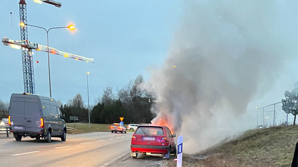 Kraftiga lågor slår upp från den brinnande bilen.