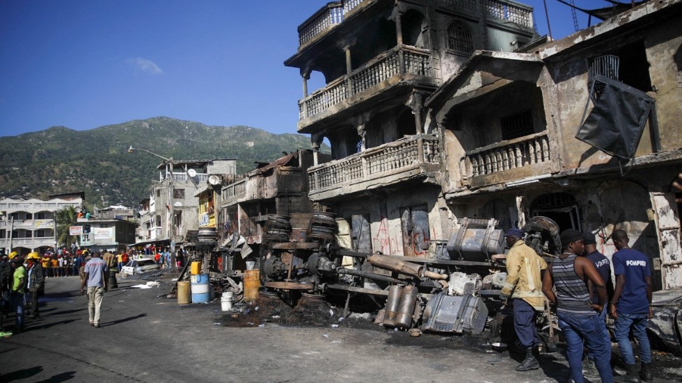 Brandmän vid resterna av den lastbil som exploderade natten till tisdag, i Cap-Haïtien.