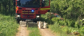 Bil började brinna under färd på skogsväg