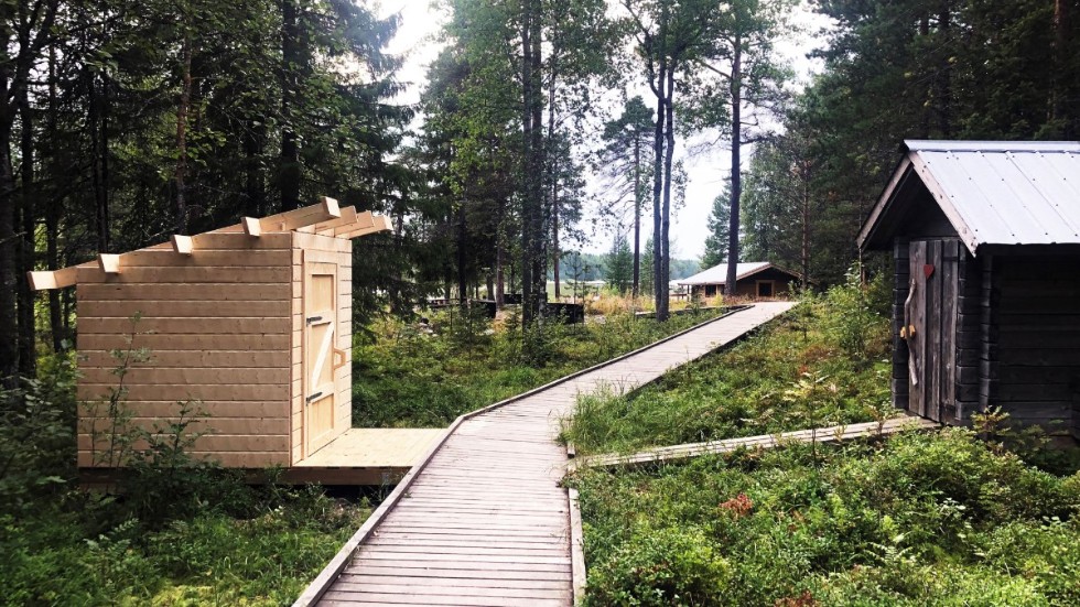 Kommunen fortsätter att bygga upp området vid Hertsöträsk efter de bränder som förstört byggnader vid området. Ett nytt tillgänglighetsanpassat dass färdigställs just nu och i bakgrunden ses den nya huvudstugan vid träskets bas.