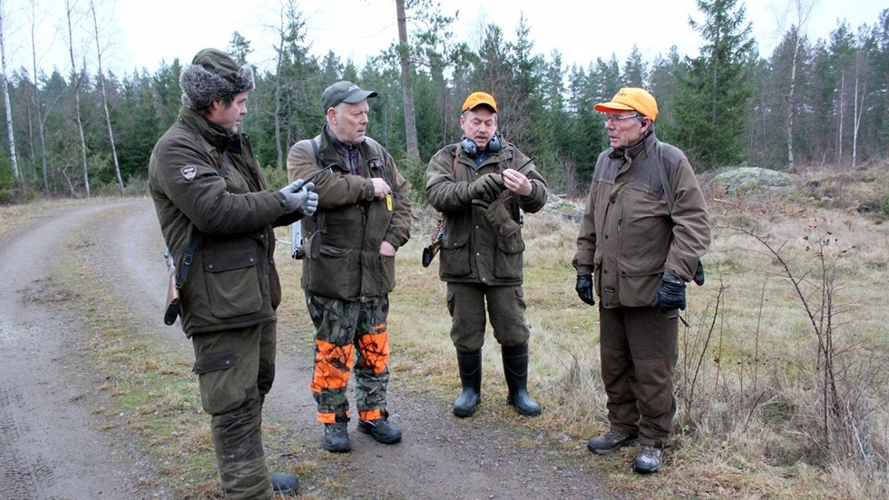 Jan Söderblom, Classe Klaesson, Jan Ottosson och Svante Ottosson kontrollerar jaktradion innan de går vidare längs med skogsvägen. Foto: Lena Dahlberg