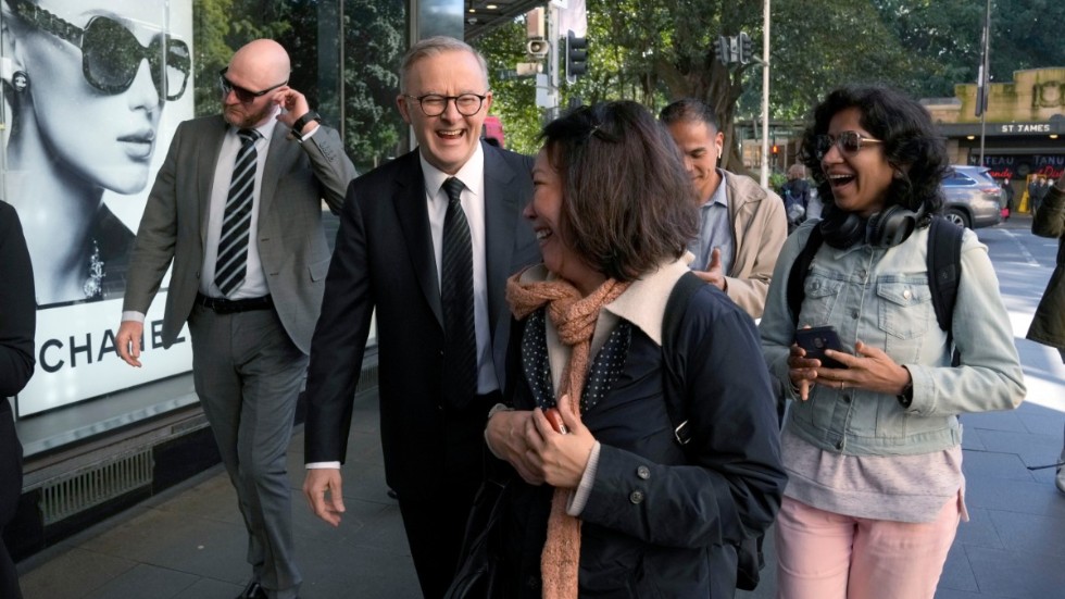 Anthony Albanese (skrattande i mitten) i Sydney i samband med sitt utspel om resan till London.