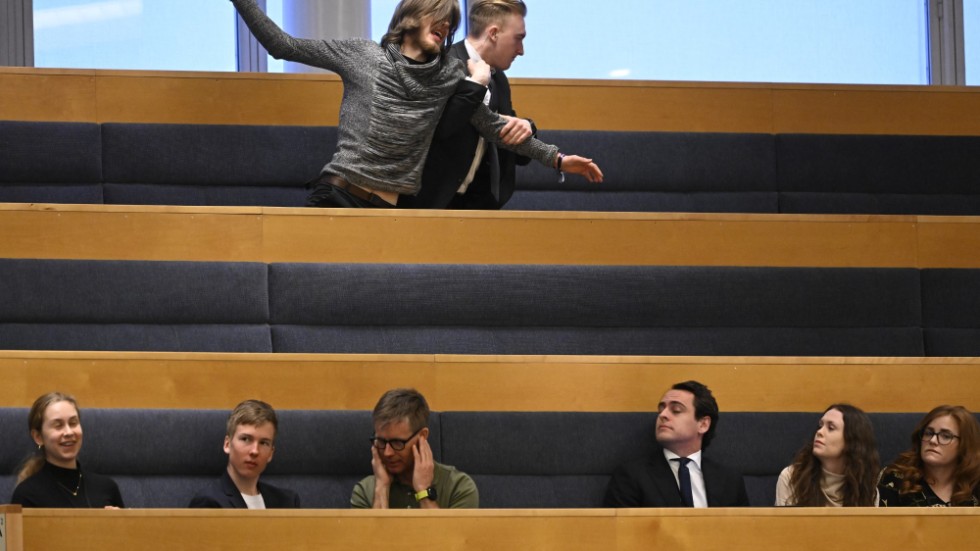 Mannen som protesterade fördes bort av vakter.
