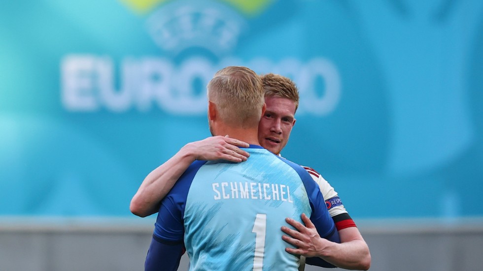 Danmarks målvakt Kasper Schmeichel och Belgiens matchavgörare Kevin De Bruyne kramar om varandra på Parken i Köpenhamn.
