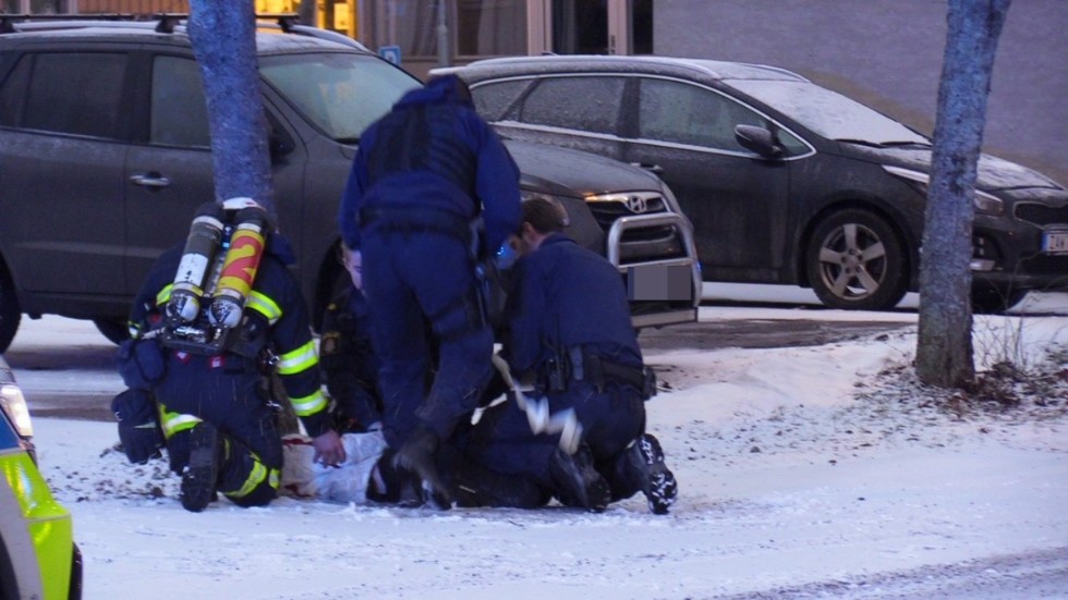 Polis och brandmän hjälps åt vid gripandet.