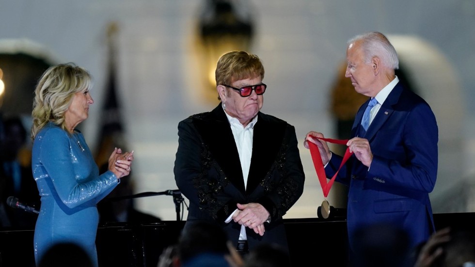 President Joe Biden delar ut medalj till Elton John medan hans fru Jill Biden ser på.