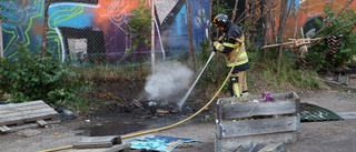 Larm om brand i byggnad – var sopor på marken