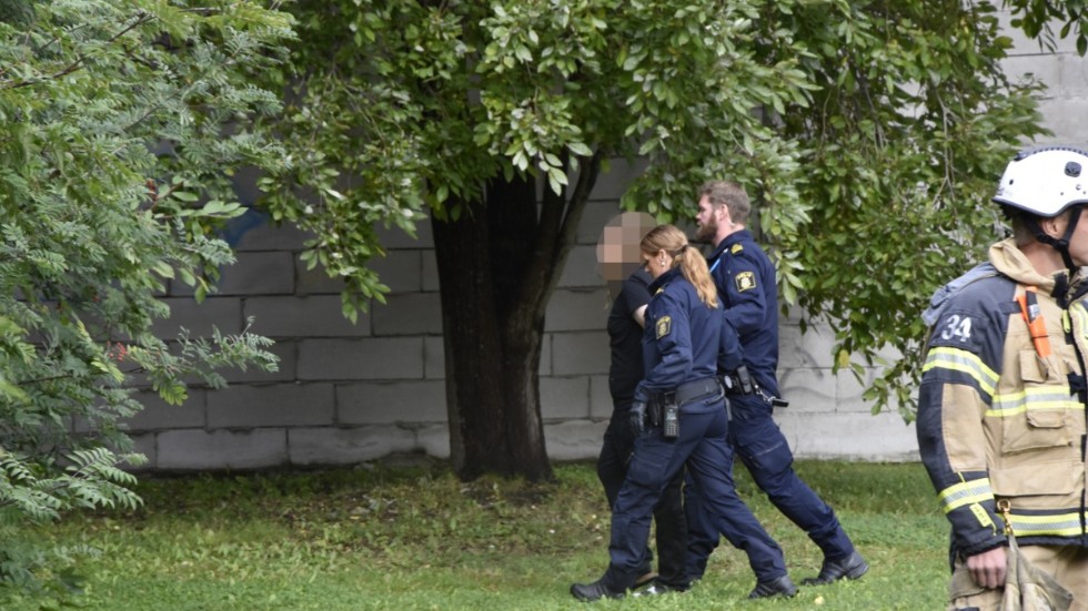 Den misstänkte mannen förs bort till en polisbil efter gripandet i lördags.