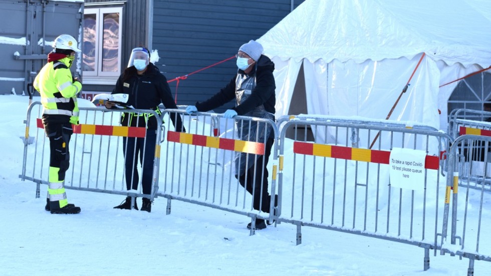 En person som jobbar vid byggandet av Northvolt Ett väntar på sitt svar vid testtältet utanför entren. Nu kommer bara
