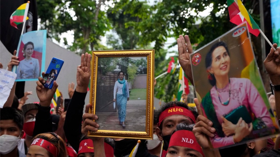 Myanmarier i Thailand håller upp bilder på den avsatta myanmariska ledaren Aung San Suu Kyi under en protest utanför Myanmars ambassad i Bangkok i juli.