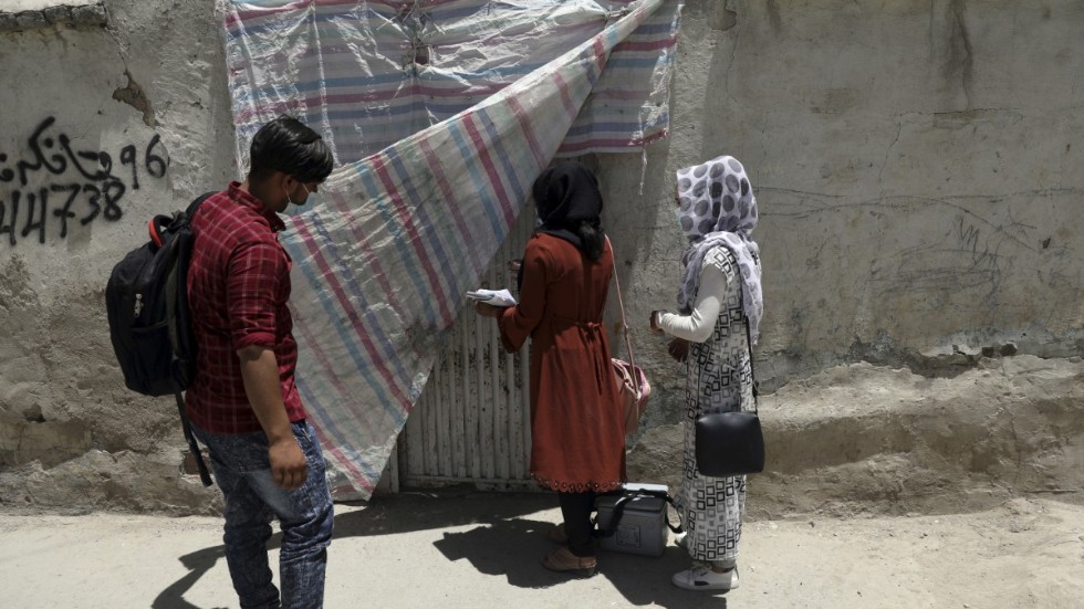 Sjukvårdsarbetare knackar dörr i Kabul, Afghanistan, som del av en vaccinationskampanj mot polio. Minst fem personer som arbetar med poliovaccinationer sköts till döds i östra Afghanistan på tisdagen.
