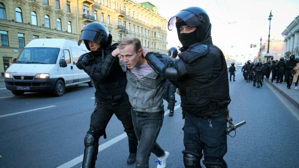 Ryska kravallpoliser för iväg en demonstrant i S:t Petersburg på lördagen.