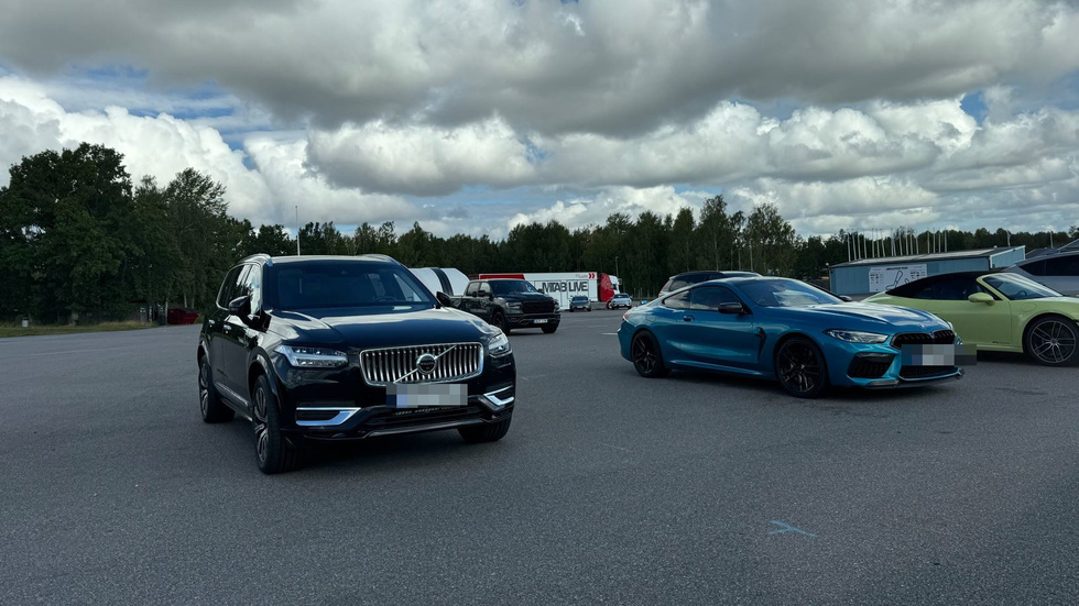 Kungens blå BMW till höger och livvakternas Volvo till vänster. 