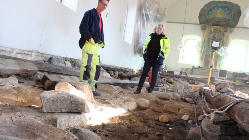 Rikard Hedvall, arkeolog, arbetar med utgrävningarna i Hallingebergs kyrka. Till höger: Annika Deltin, fastighetsansvarig.