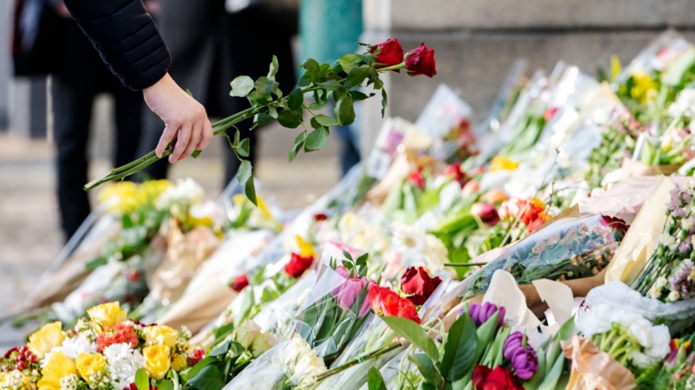 Rosor placeras i havet av blommor och ljus på trappan vid huvudentrén på Malmö Latinskola den 22 mars, dagen efter att två av skolans lärare dödats av en elev. Arkivbild.