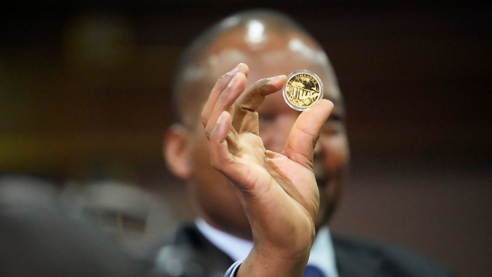 Centralbankschefen John Mangudya visar upp de nya guldmynten i Harare. Bilden är från lanseringen i juli.