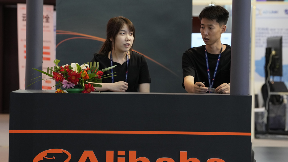 Ett negativt besked från e-handelsjätten Alibaba tynger börserna i Asien i fredagens handel. Arkivbild från företagets monter på en mässa i Peking i somras.