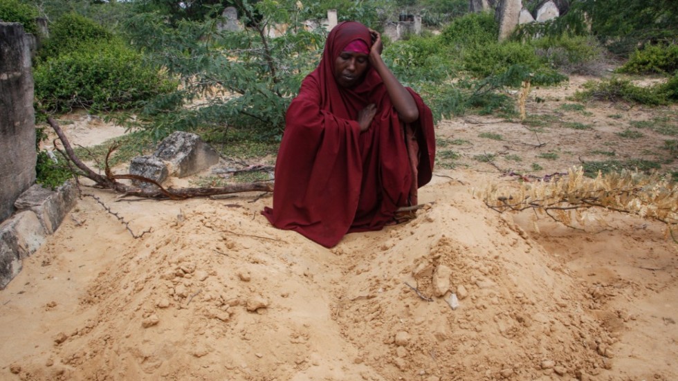 Fatuma Abdi Aliyow vid sina två söners gravar utanför Mogadishu. De avled nyligen av undernäringsrelaterade sjukdomar.