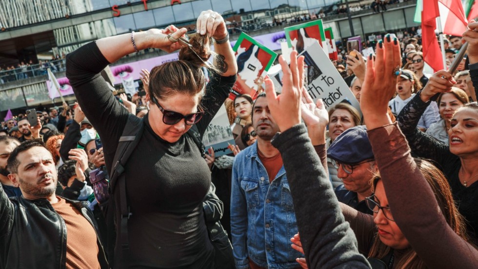 Azita Eriksson klipper av sitt hår under en demonstration i Stockholm till stöd för protesterna i Iran.