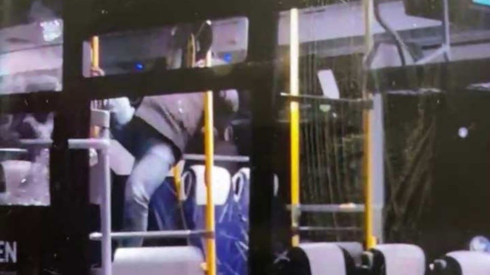 Mannen häver sig över sätena i bussen. 