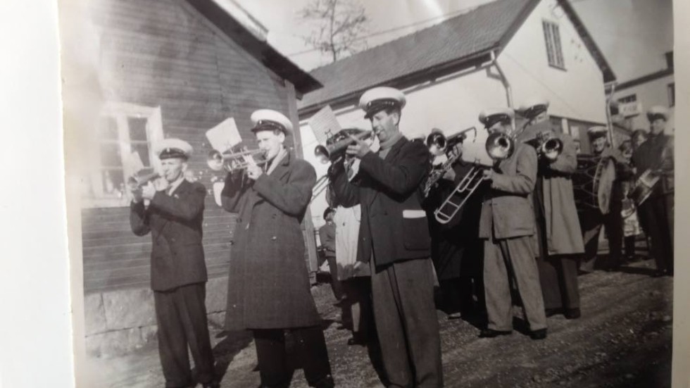 Kåren. Musikkåren musicerar på 1 maj. Längst till vänster Sören Svensson och längst till höger Paul Holmberg. Min far skymtar fram i bakgrunden med stora bastrumman