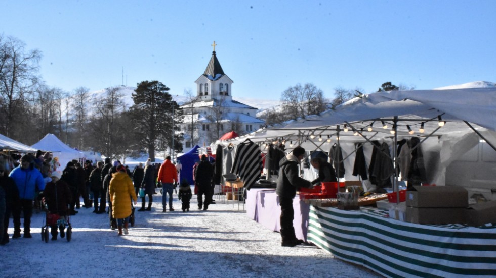 Gällivare vintermarknad på sitt nya ställe på den tillfälliga parkeringen vid Kunskapshuset. Här i bakgrunden syns Gällivare kyrka.