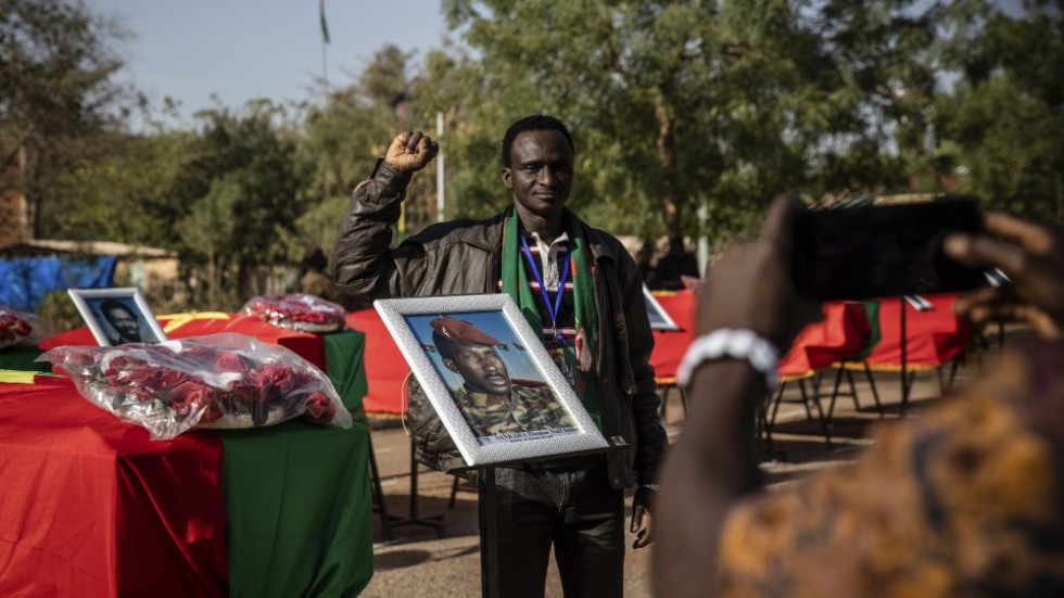 En man poserar bredvid kistan innehållandes Thomas Sankaras kvarlevor i Burkina Fasos huvudstad Ouagadougou.