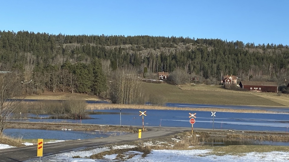 Vid järnvägsövergången i Gruvdalen är det ordentligt blött på båda sidor om spåret och vägen. Tjustbanan.