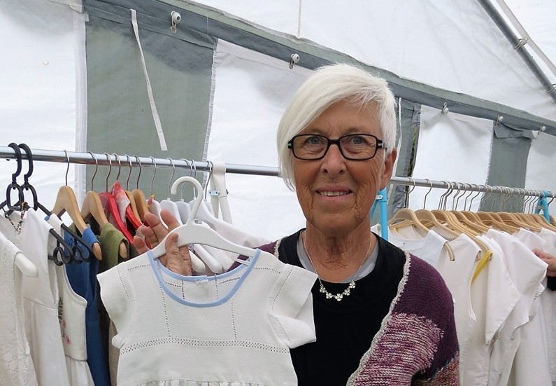 Elisabeth Larsson syr kläder av lakan och dukar, här en barnklänning av en linneduk.