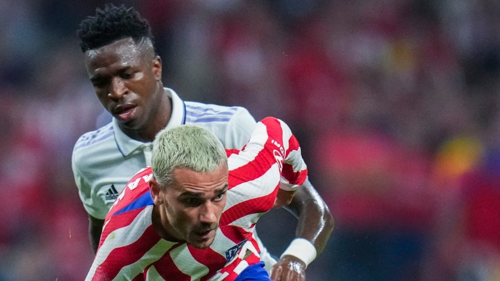 Real Madrids Vinícius Júnior, i vit tröja, mot Atlético Madrids Antoine Griezmann, i rödvit tröja, i Madridderbyt.