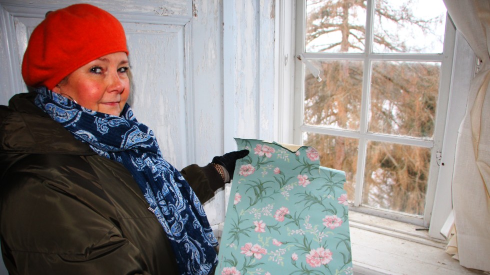 Museipedagog Ragnvi Andersson visar upp tapeten som fått sitt namn av Emilie Piper. Motivet "Emilie" ingår i den nya Löfstadskollektionen.