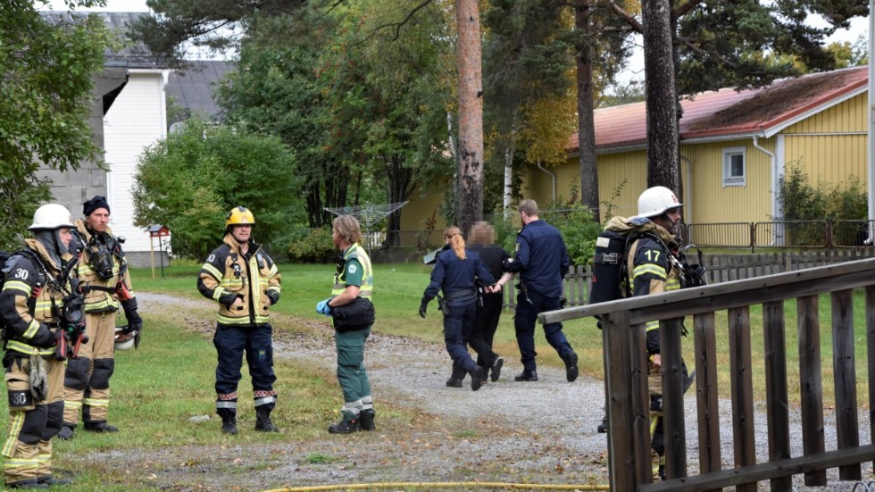 Misstänkte mannen blir bortförd av polisen efter att han gripits misstänkt för mordbrand.