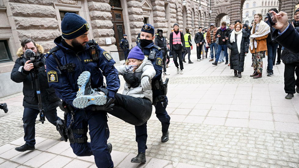 Greta Thunberg bärs bort till en polisbuss.