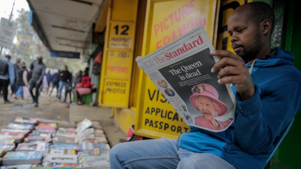 En tidningsförsäljare läser nyheten om drottning Elizabeths död i Kenyas huvudstad Nairobi.
