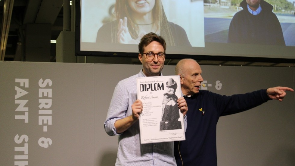 Robert Aman tar emot Svenska Serieakademins prestigefyllda diplom under Bokmässan i Göteborg. 