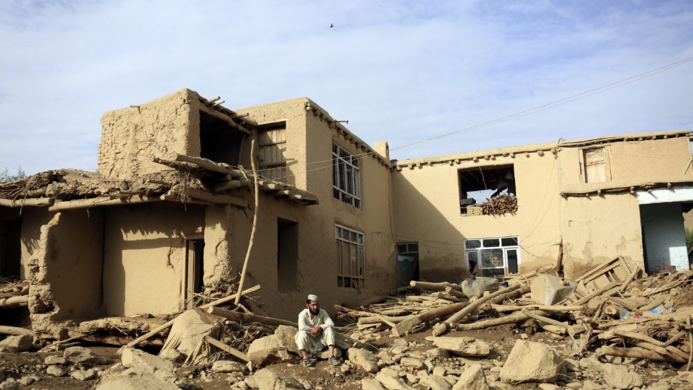 En man utanför sin förstörda bostad i provinsen Maidan Wardak i Afghanistan efter att monsunregn drabbat området.