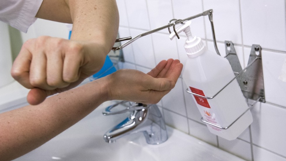 Vårdpersonal tvättar sig med handsprit.