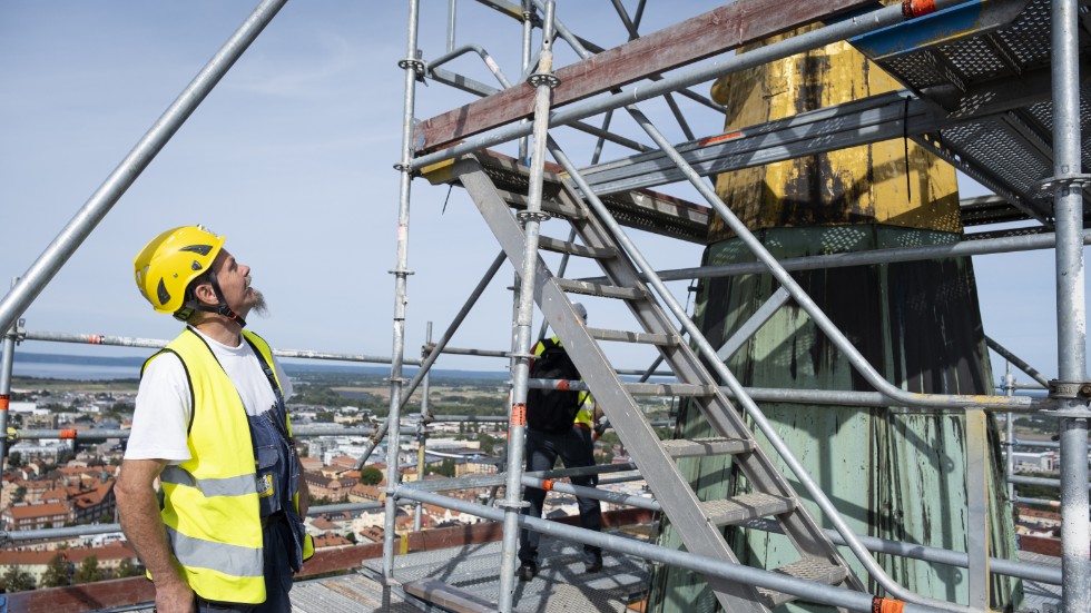 Den åtta meter höga guldspiran är högre än man kan tro när man ser den från marken. Plåtslagare Niclas Bylund får böja ordentligt på nacken för att se hela.