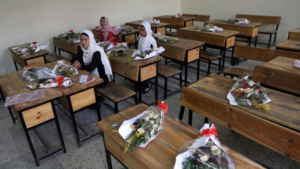 Flickor i en skola i Afghanistans huvudstad Kabul med blommor på de bänkar där klasskamrater som dödats suttit. Arkivbild.