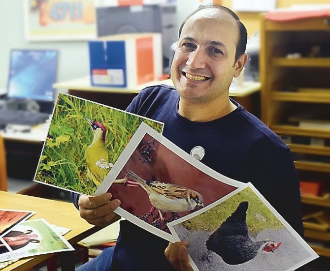 Mohamed visar upp fotografier med tema fåglar.