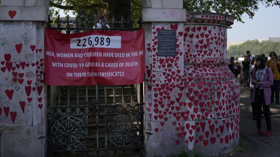 Turister går förbi minnesmonumentet "The National Covid Memorial Wall" i London, som är tillägnat de britter som dog under coronapandemin.