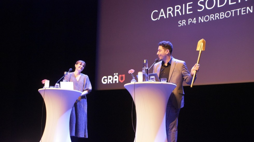Carrie Söderberg från P4 Norrbotten får överta spaden och ansvaret som grävgeneral inför 2022 års konferens av Fouad Youcefi, ordförande för Föreningen Grävande Journalister.